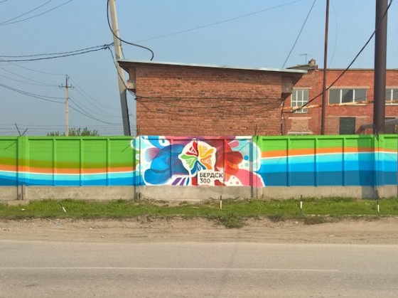 Граффити с логотипом 300-летия нарисовал художник на заборе в промзоне Бердска